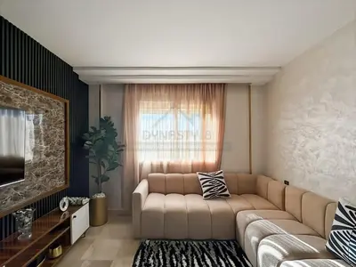 a living room with a couch and a television at Confort Moderne au Cœur de Marrakech Proche Gare in Marrakech