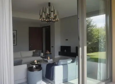a living room with a couch and a chandelier at Villa Oasis de Verre - Atlas Golf & Pool in Marrakech