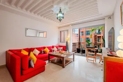 a living room with a red couch and a table at 1-Bedroom Apartment in Guéliz Center , 10 Min Jemaa El-Fna in Marrakech
