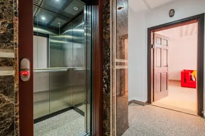 a glass door leading into a room with a red couch at 1-Bedroom Apartment in Guéliz Center , 10 Min Jemaa El-Fna in Marrakech