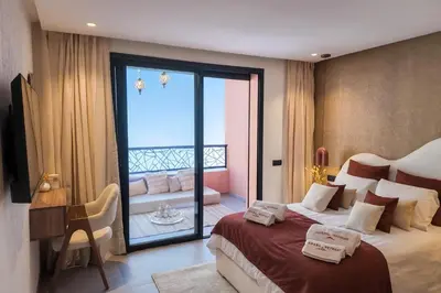 a hotel room with a bed and a balcony at Le Sahara Retreat - 2 prs - Piscine - Wifi in Marrakech