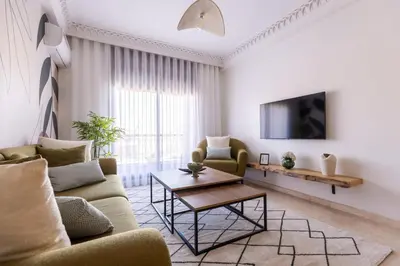 a living room with a couch and a table at One bedroom studio in Guéliz, pool & gym in Marrakech