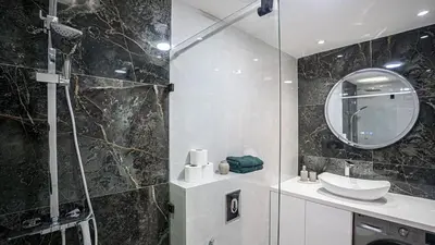 a bathroom with a shower and a sink and a mirror at Appartement Chic avec Piscine au Cœur de Gueliz in Marrakech