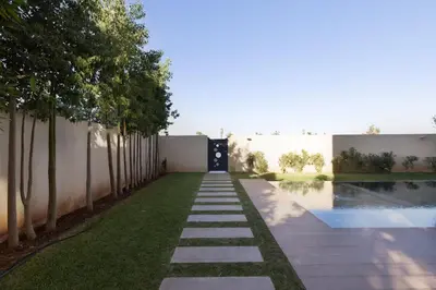 a garden with a walkway leading to a pool at Momiji Golf Villa - Private Heated Pool in Marrakech