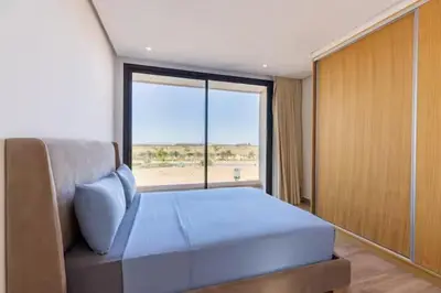 a bedroom with a bed and a large window at Momiji Golf Villa - Private Heated Pool in Marrakech