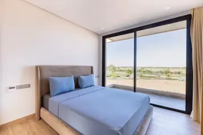 a bedroom with a large bed and a large window at Momiji Golf Villa - Private Heated Pool in Marrakech