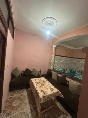 a living room with a couch and a table at Maison confortable pour familles in Zaouia El Hedil Mamra