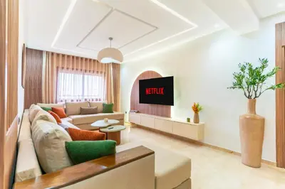 a living room with a couch and a tv at Menara Suite Harmonie , Terrasse et Piscine in Marrakech
