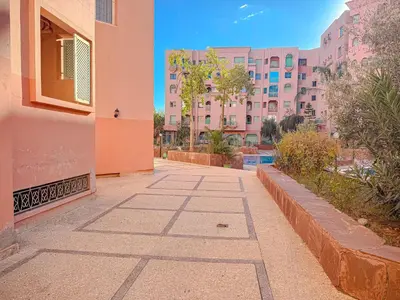 a walkway in a city with pink buildings at Séjour Élégant et raffiné à Hivernage 2 ch & parking privé in Marrakech