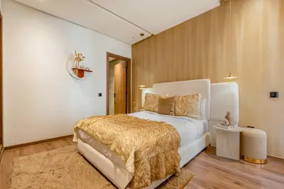 a bedroom with a white bed with a gold blanket at Le Lotus - Piscine intérieur et extérieur - Wifi - Fitness in Marrakech