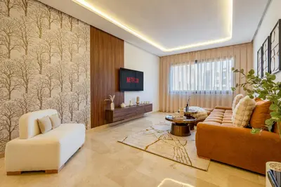 a living room with a couch and a tv at Le Lotus - Piscine intérieur et extérieur - Wifi - Fitness in Marrakech