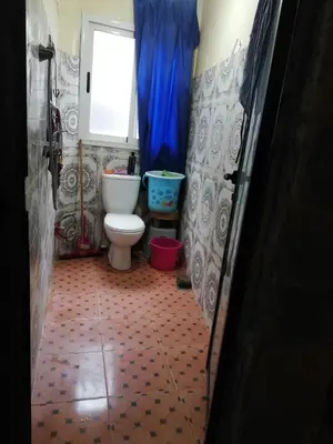a bathroom with a toilet and a blue curtain at famile 154 in Marrakech