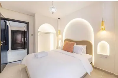 a bedroom with a white bed with an arched window at Simone moves to Guéliz in Marrakech