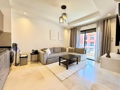 a living room with a couch and a table at Cosy appartement , Marrakech Noria golf in Marrakech
