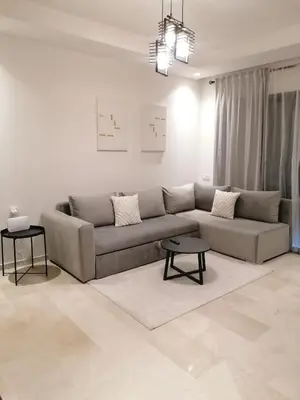 a living room with a couch and a table at Cosy appartement , Marrakech Noria golf in Marrakech