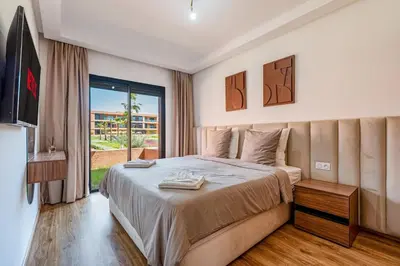 a bedroom with a bed and a large window at Noria Golf Marrakech pool view 2 bedrooms garden in Marrakech