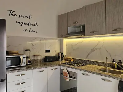 a kitchen with white cabinets and a sink and a microwave at Amber Haven in Marrakech