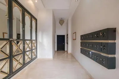 a hallway with a wooden door and a hallway with white walls at Almaya Stay City Center in Marrakech