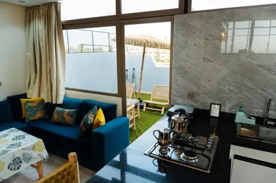 a living room with a blue couch and a large window at Appartement moderne in Marrakech