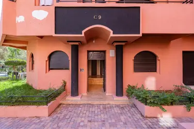 an orange house with a brick walkway leading to the door at New 2BR Apartment in Marrakech with Pools, Gym, Security & Terrace in Marrakech