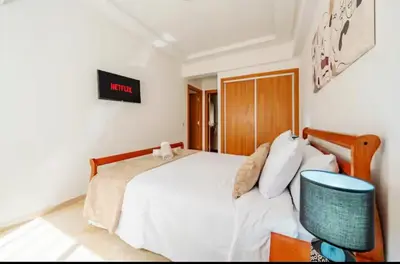 a bedroom with a bed and a desk with a tv at Luxury apartment in Hivernage in Marrakech