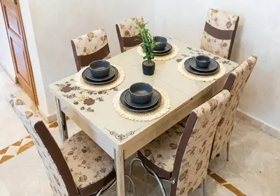 a table with four chairs and a table with hats on it at Andalous Prestige in Marrakech