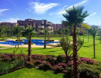 a resort with a pool and palm trees and flowers at Prestigia Golf View - Piscine & terrasse in Marrakech