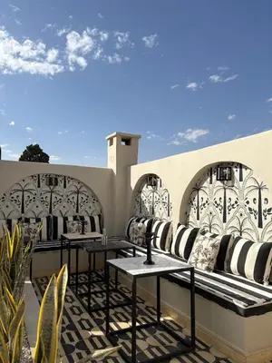 a patio with tables and couches on a building at Private Riad in Marrakech Medina in Marrakech
