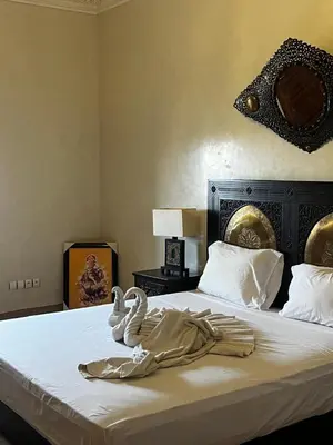 a bed with two swans towels sitting on it at Villa Oum Palace in Marrakech