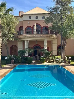 a large house with a swimming pool in front of it at Villa Oum Palace in Marrakech