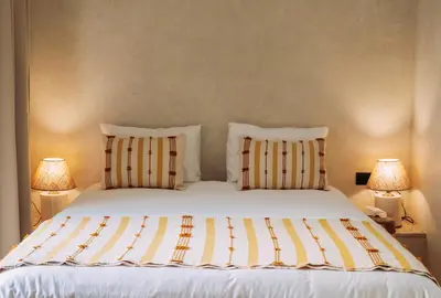 a bedroom with a bed with two pillows and two lamps at Riad Ever - Entièrement privatisé in Marrakech