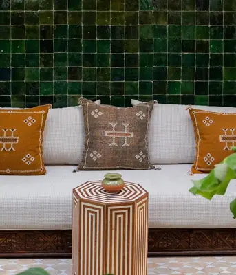 a couch with pillows and a table with a bowl on it at Riad Ever - Entièrement privatisé in Marrakech