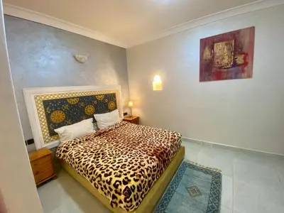 a bedroom with a bed with a leopard print blanket at Villa d'Exception avec Piscine Privée in Marrakech
