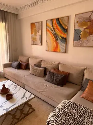 a living room with a couch and paintings on the wall at Le petit cocon in Marrakech