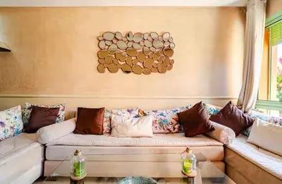 a living room with a couch with many pillows at Appartement marrakech garden in Marrakech