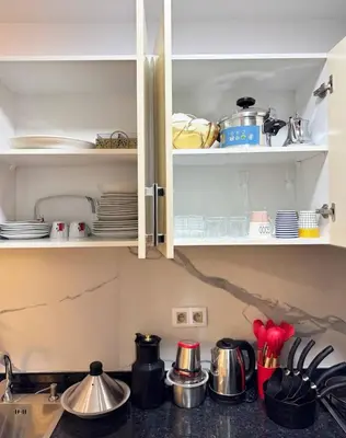 a kitchen cabinet with dishes and utensils in it at Gueliz Bright & Modern 2BR 2 Balcons in Marrakech