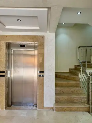 a metal elevator in a building with stairs at Gueliz Bright & Modern 2BR 2 Balcons in Marrakech
