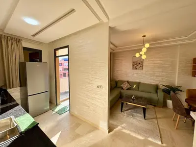 a living room with a green couch and a refrigerator at Gueliz Bright & Modern 2BR 2 Balcons in Marrakech