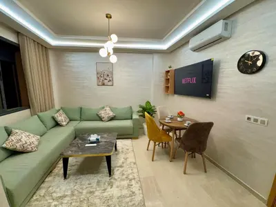 a living room with a green couch and a table at Gueliz Bright & Modern 2BR 2 Balcons in Marrakech