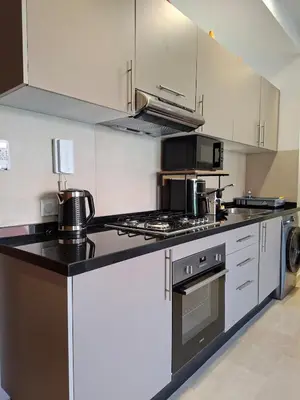 a kitchen with white cabinets and a stove top oven at Noria Golf Marrakech Pool in Marrakech