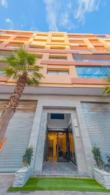 a building with a palm tree in front of it at MOZAIC26 I Terrasse & Piscine couverte I Hivernage in Marrakech