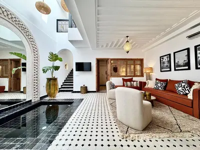 a living room with a couch and a pool at Riad Costa 2 privates pools rooftop breakfast in Marrakech