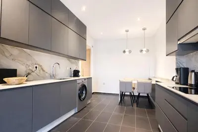 a kitchen with gray cabinets and a sink and a dishwasher at Luxury 2 Bedroom Apartment Pool & Garden Wifi in Marrakech