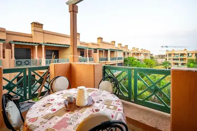 a table and chairs on a balcony with a view at Appartement de charme avec piscine a Marrakech in Marrakech