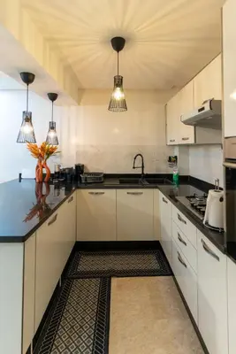 a kitchen with white cabinets and black counter tops at Bright & Chic Stay in Marrakech Gueliz in Marrakech
