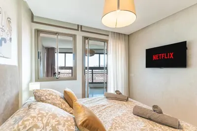 a bedroom with a bed and a tv on the wall at Bright & Chic Stay in Marrakech Gueliz in Marrakech