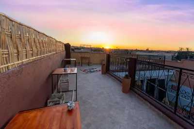 a balcony with a view of the sunset at Riad Abrare-A in Marrakech