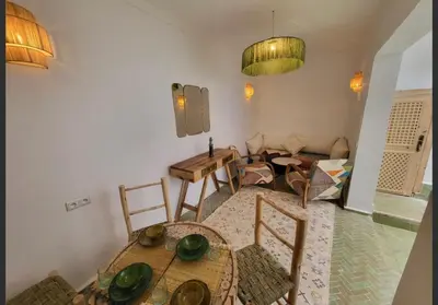 a living room with a table and chairs in a room at Riad Granada in Marrakech