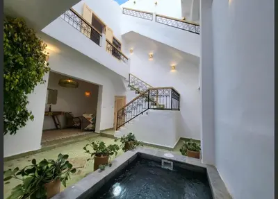 a swimming pool in the middle of a house with stairs at Riad Granada in Marrakech