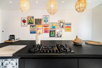 a kitchen counter with a stove and pictures on the wall at Magnifique Villa EME, Golf Amelkis Marrakech - Piscine Chauffée in Marrakech